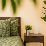 Nowoczesna sypialnia z zieloną pościelą w liście i roślinami doniczkowymi